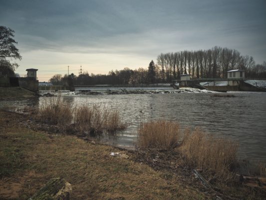 Das wer wird in seiner ganzen Ausdehnung gezeigt. Das große Tosbecken liegt vor einer angrenzenden Wiese.